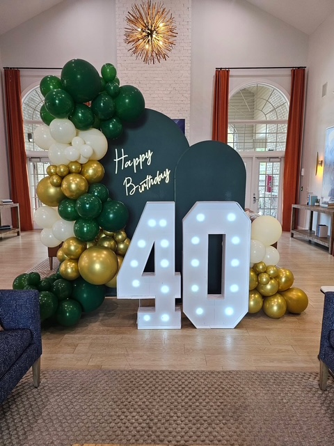 Green and gold 40th birthday balloon arch with light-up marquee numbers